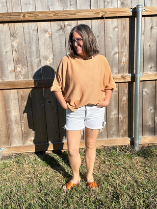 person wearing a peach sweater