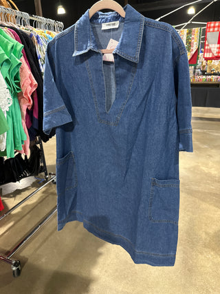  blue denim dress on a rack with a blurred store background