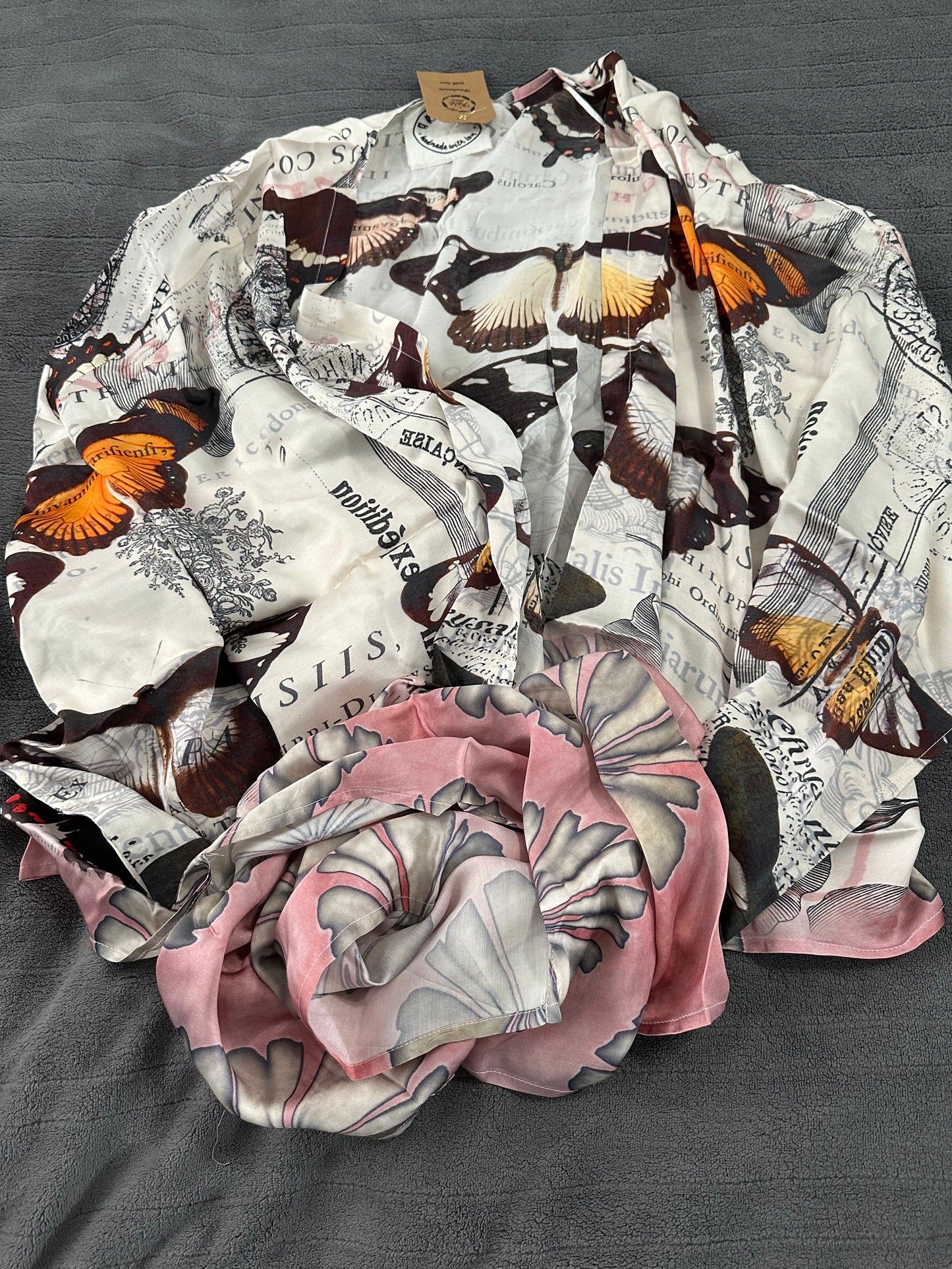 Butterfly kimono with pink pattern at the hem on a gray surface